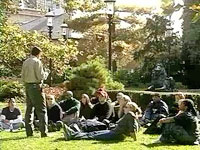 Class being taught outside with students sitting on the grass