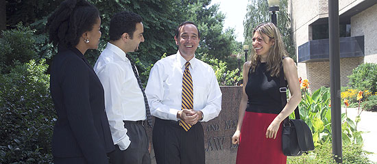 Three students and a professor outside