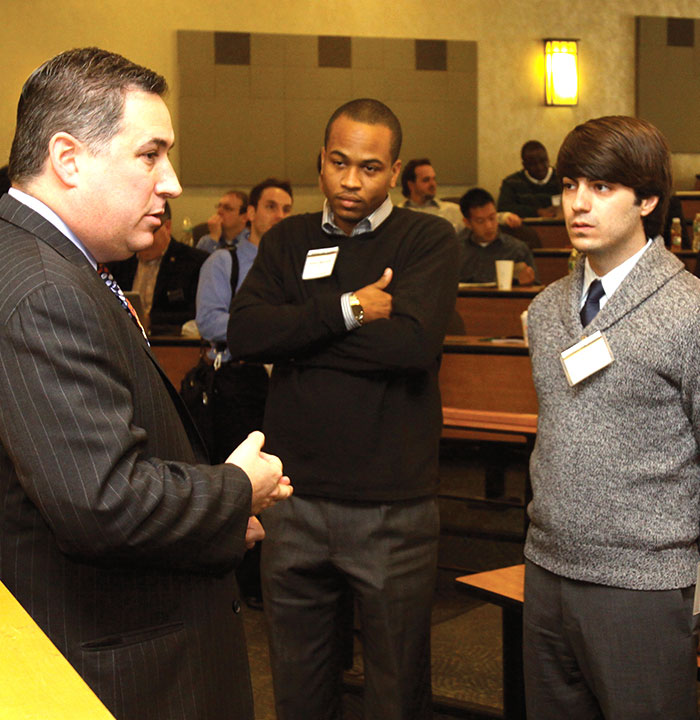 Law Alumni Speaking with Two Law Students After an On Campus Event