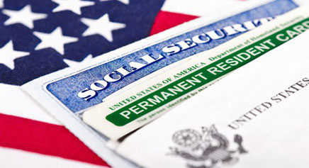 A photo of the United States flag, a social security car and a permanent resident card. 