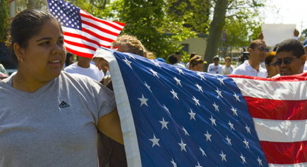 Photo of people holding an American Flag.