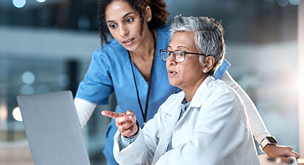 Doctors discussing case in front of a computer screen