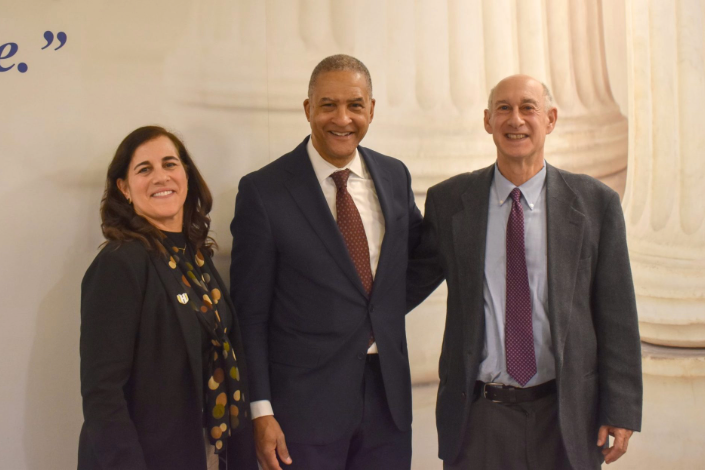 Three legal professionals posing together at a formal law lecture event in front of a courthouse-style backdrop, Kaplan Lecture 2026.