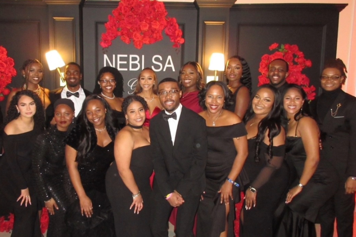 A group of students from Hofstra Law's Black Law Student Association smile and pose for a picture together dressed in black tie attire at the NEBLSA Convention.