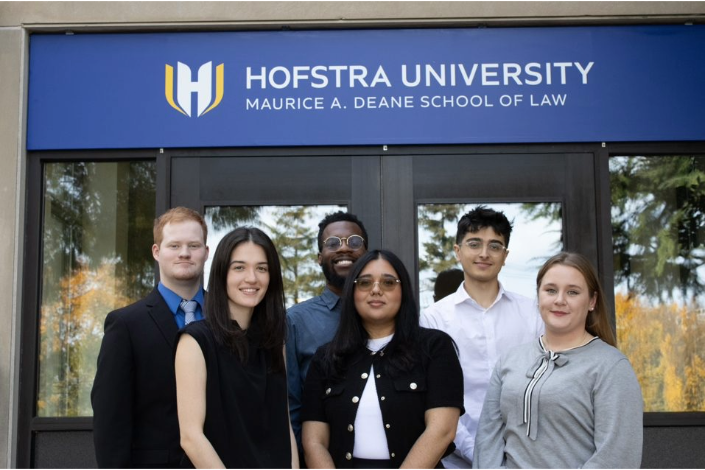 Six fellows from the Deans' Legal-Tech Fellowship pose for a picture together in front of the Hofstra Law building.